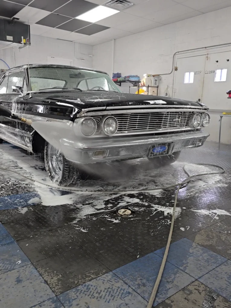 Classic car being hand washed inside the WashNWerk shop